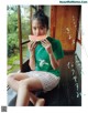 A woman sitting on a window sill eating a slice of watermelon.