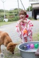 A woman in a kimono playing with a dog.