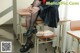 A woman in a school uniform sitting on a chair.