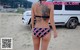 A woman in a bikini with a tattoo on her back.