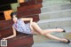 A woman in a blue and white dress laying on some steps.