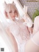 A woman in a white lingerie holding a fan.